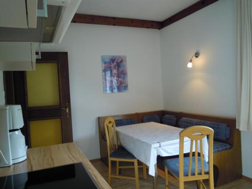 a dining room with a table and chairs and a kitchen at Ferienwohnungen Familie Jarnig Inge in Görtschach