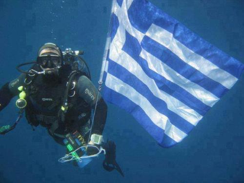 a diver in the water next to a flag at Apollon Apartments H-2 in Rhodes Town