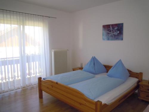 a bedroom with a bed with blue pillows on it at Ferienwohnungen Familie Jarnig Inge in Görtschach