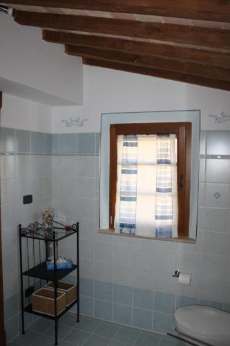 a bathroom with a toilet and a window at Alla Porta di Sopra in Castiglione dʼOrcia