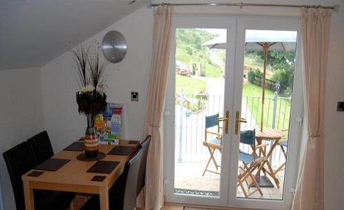 a dining room with a table and a sliding glass door at Winchfawr Lodge in Merthyr Tydfil