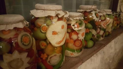 a row of jars filled with fruit and vegetables at Pensiunea Casa Dacilor in Podeni