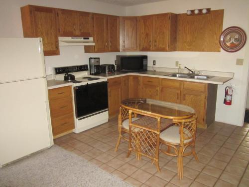 a kitchen with a table and a sink and a refrigerator at Dodgeton Creek Inn in Cuchara