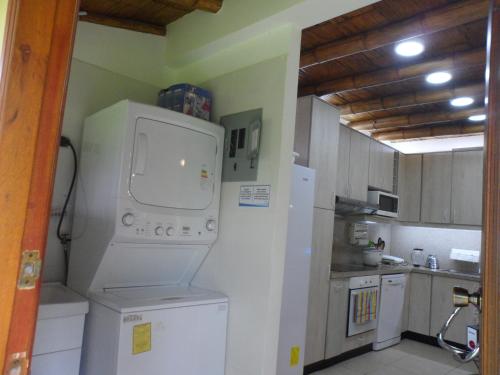 a kitchen with a washing machine and a washer at Hospedajes de Pato in Olón