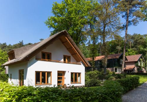 a white house with a thatched roof at Relais & Chateaux Hotel Landgoed Het Roode Koper in Ermelo