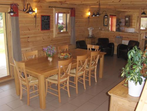 ein Esszimmer mit einem Holztisch und Stühlen in der Unterkunft Les Bruchels, Longechaux in Longechaux