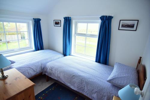 a bedroom with two beds and a window at Tollgate Cottages Bed and Breakfast in Freshwater