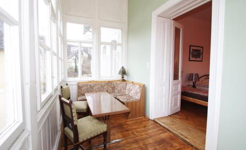 a dining room with a table and chairs and windows at Raisa Apartments Fünkhgasse in Pressbaum