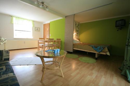 a living room with a table and chairs and a bed at Ferienhaus Schwalbe Seebad Lubmin in Lubmin