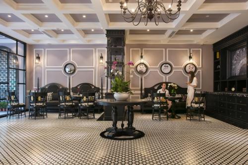 a woman standing in a restaurant with clocks on the wall at JM Marvel Hotel & Spa in Hanoi