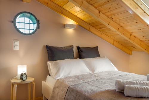 a bedroom with a white bed with a window at Tamaris Beach House in Acharavi