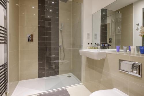 a bathroom with a shower and a toilet and a sink at Tailored Stays - Flamsteed Duplex Apartment in Cambridge
