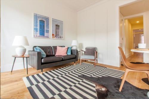 uma sala de estar com um sofá e um tapete em Restauradores Prestige em Lisboa