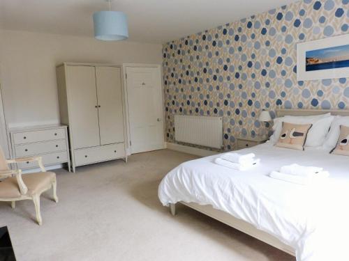 ヴェントナーにあるLittle Grosvenorの白いベッドと模様の壁が備わるベッドルーム1室
