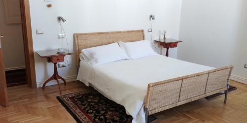 a bedroom with a large bed with two tables at Palazzo De Giorgi B&B in Lecce