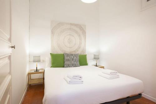 バルセロナにあるStay U-nique Apartments Granadosの緑をアクセントにした白い大型ベッド付きのベッドルーム1室