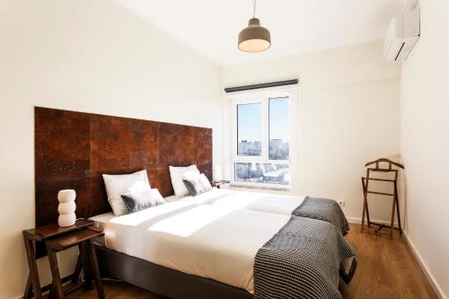 een slaapkamer met een groot bed en een groot raam bij WHome | Anjos Premium Apartment #8 in Lissabon