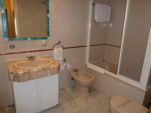 a bathroom with a sink and a toilet and a tub at Casinomar in Benalmádena