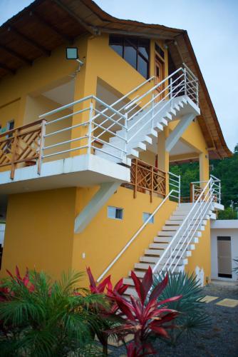 a yellow building with stairs and plants in front of it at Hotel Soberao in Esmeraldas