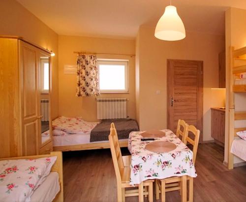 a room with a table and a bed and a bedroom at Agroturystyka Źródełko in Święta Katarzyna