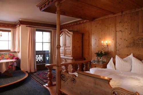 a bedroom with a bed in a room with wooden walls at Das Traditionshotel Schwarzer Adler in Tannheim