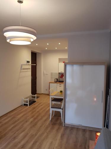 een woonkamer met een tafel en een witte muur bij Apartamenty Marco 3 przy Dworcu-Stare Miasto-Super Wi Fi in Krakau