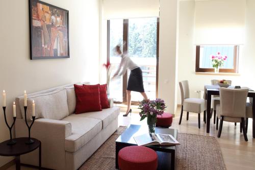 a woman is walking into a living room at Euphoria Club Hotel in Borovets