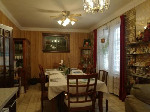 ein Esszimmer mit einem Tisch und einem Deckenventilator in der Unterkunft Ambassador B&B Guest Home in Stratford