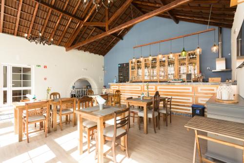 a restaurant with wooden tables and wooden chairs at Ericeira Soul Guesthouse in Ericeira