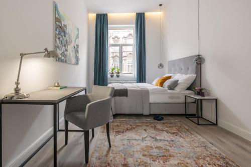 Montevideo Deluxe Apartments في زغرب: غرفة نوم بسرير ومكتب وكرسي