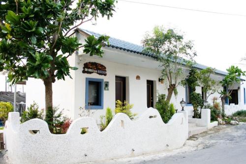a white building with a fence in front of it at Borabora B&B in Nanwan