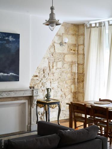 a living room with a table and a stone wall at Bordeaux Village Blaye in Blaye