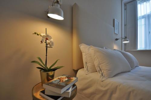 a bedroom with a bed and a table with a flower at Porto Charming Hotel in Porto