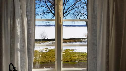 a window with a view of a snow covered field at Hotell Grönfeltsgården in Karlskoga