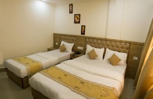 a bedroom with two beds with white sheets at Nexstay Crystal Residency in Kozhikode