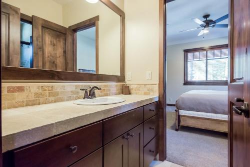 a bathroom with a sink and a mirror and a bed at Gray Bear 454 in Mammoth Lakes