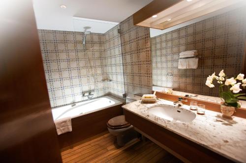 La salle de bains est pourvue d'une baignoire, d'un lavabo et de toilettes. dans l'établissement Michel Chabran - Teritoria, à Pont-de-lʼIsère