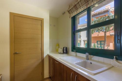 サンミゲル・デ・アボナにあるOkeanos Villa front line San Blasのバスルーム(洗面台、窓付)