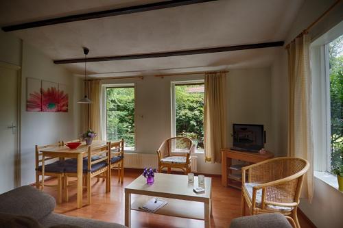 ein Wohnzimmer mit einem Esstisch und Stühlen in der Unterkunft De Kleine Kriemelkuil in Ermelo