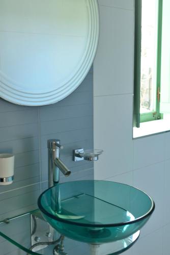 a glass sink in a bathroom with a mirror at The Burrow Guest House in Tarxien