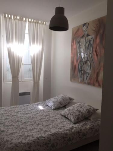 a bedroom with a bed with two pillows on it at Bordeaux Village Blaye in Blaye