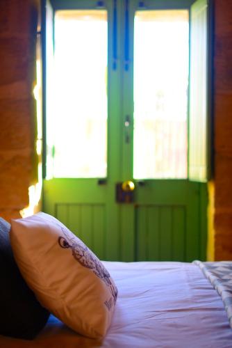 a bed with a pillow sitting on top of it at The Burrow Guest House in Tarxien
