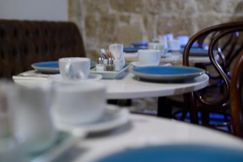 a table with blue and white dishes on it at The Burrow Guest House in Tarxien