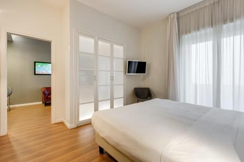 a bedroom with a white bed and a large window at Villa Maria Hotel & SPA in Francavilla al Mare