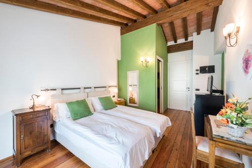 a bedroom with a white bed and green walls at Agriturismo Cà Del Lago in Gravedona