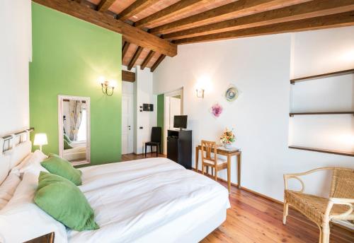 a bedroom with a white bed and green walls at Agriturismo Cà Del Lago in Gravedona