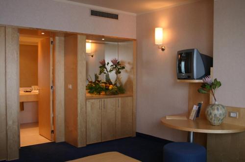 una camera d'albergo con bagno con fiori sul muro di Nicotel Bisceglie a Bisceglie