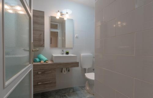 a bathroom with a toilet and a sink and a mirror at Apartments Magdalena in Crikvenica