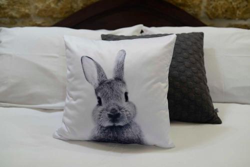 a pillow with a picture of a rabbit on a bed at The Burrow Guest House in Tarxien