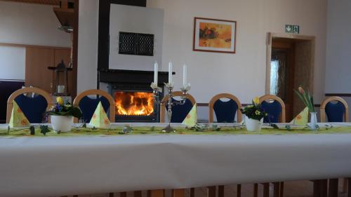 a table with a fireplace in the middle of a room at Landpension Wendfeld in Sanitz